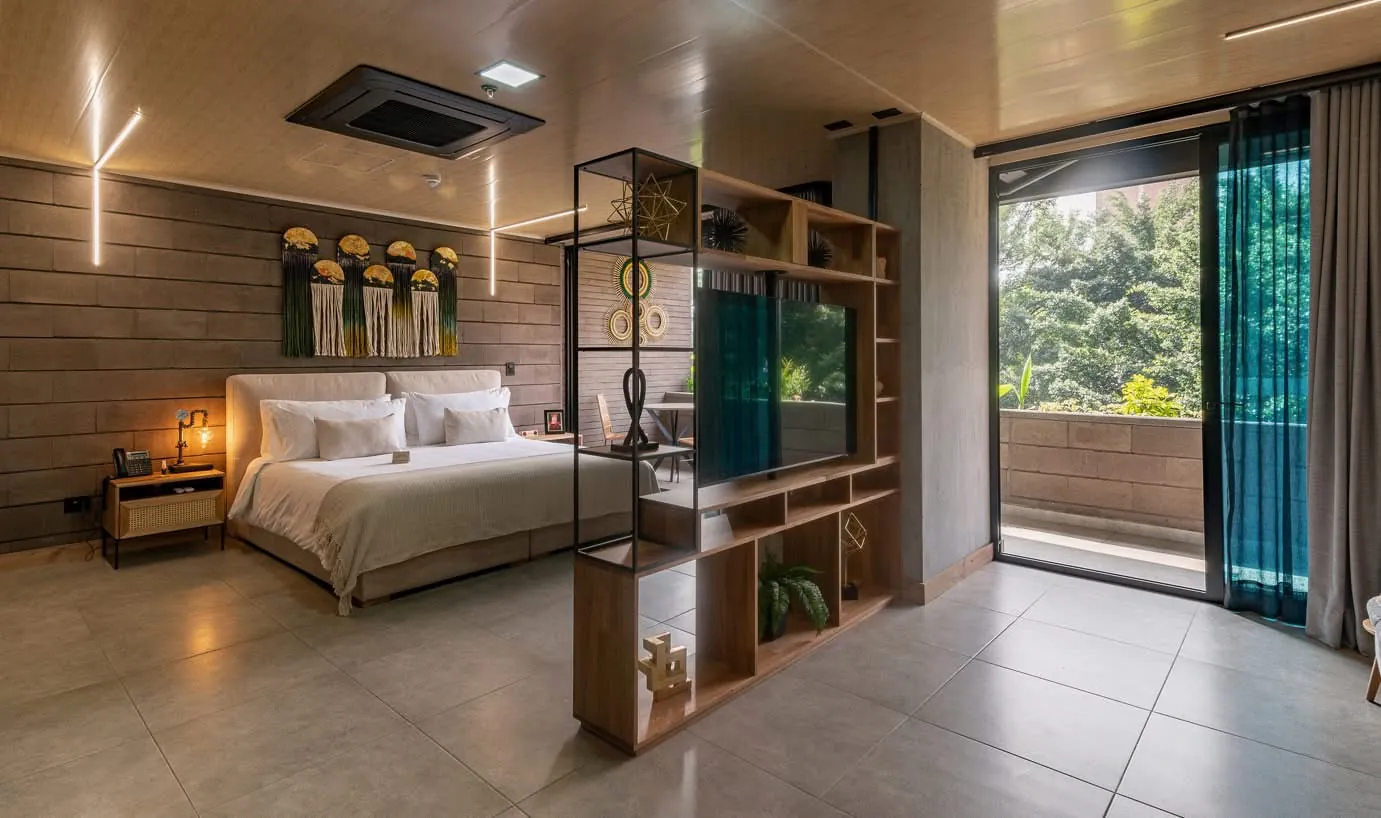 Suite con cama, estantería divisoria y balcón