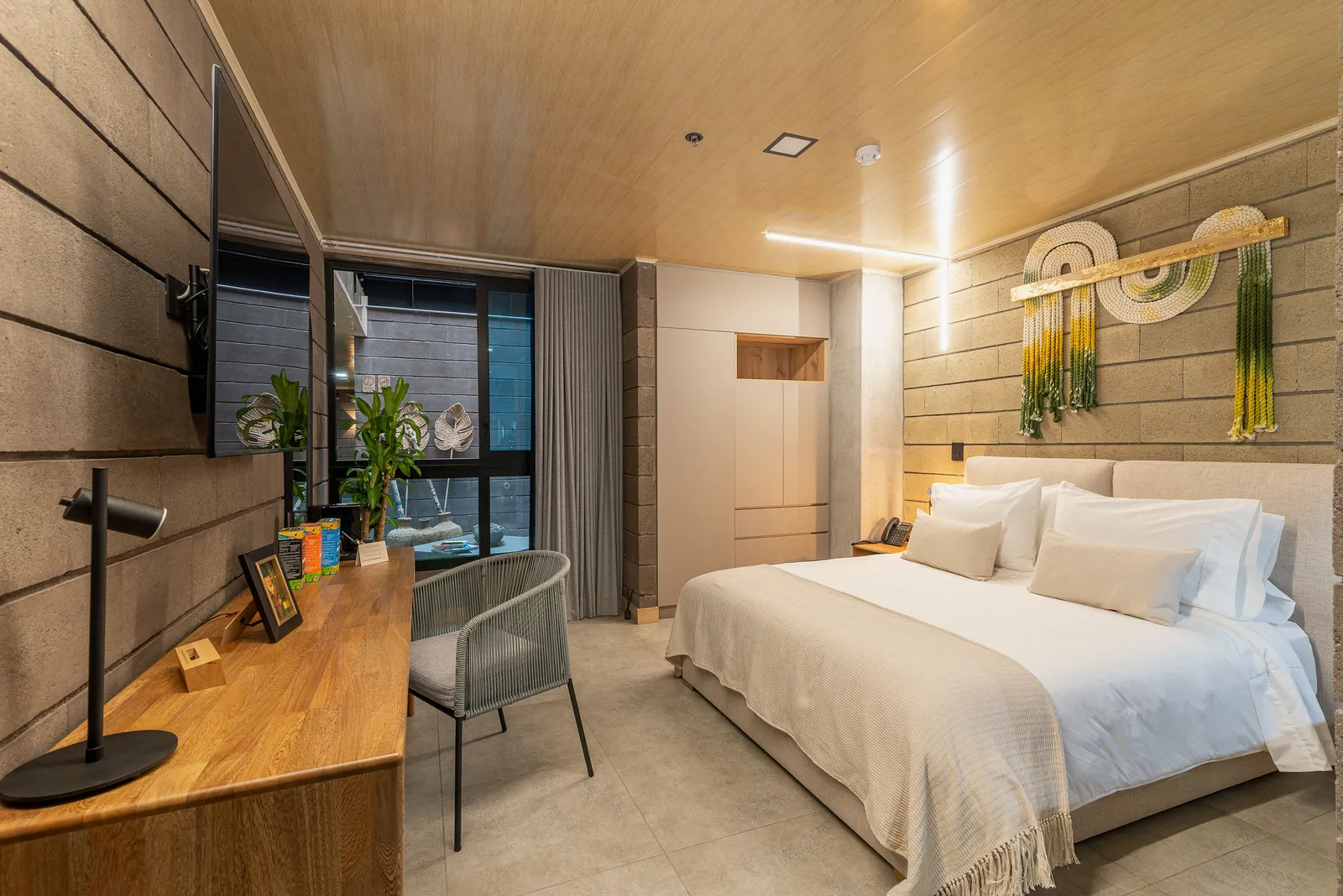 Suite Deluxe con cama king, escritorio y arte en macramé