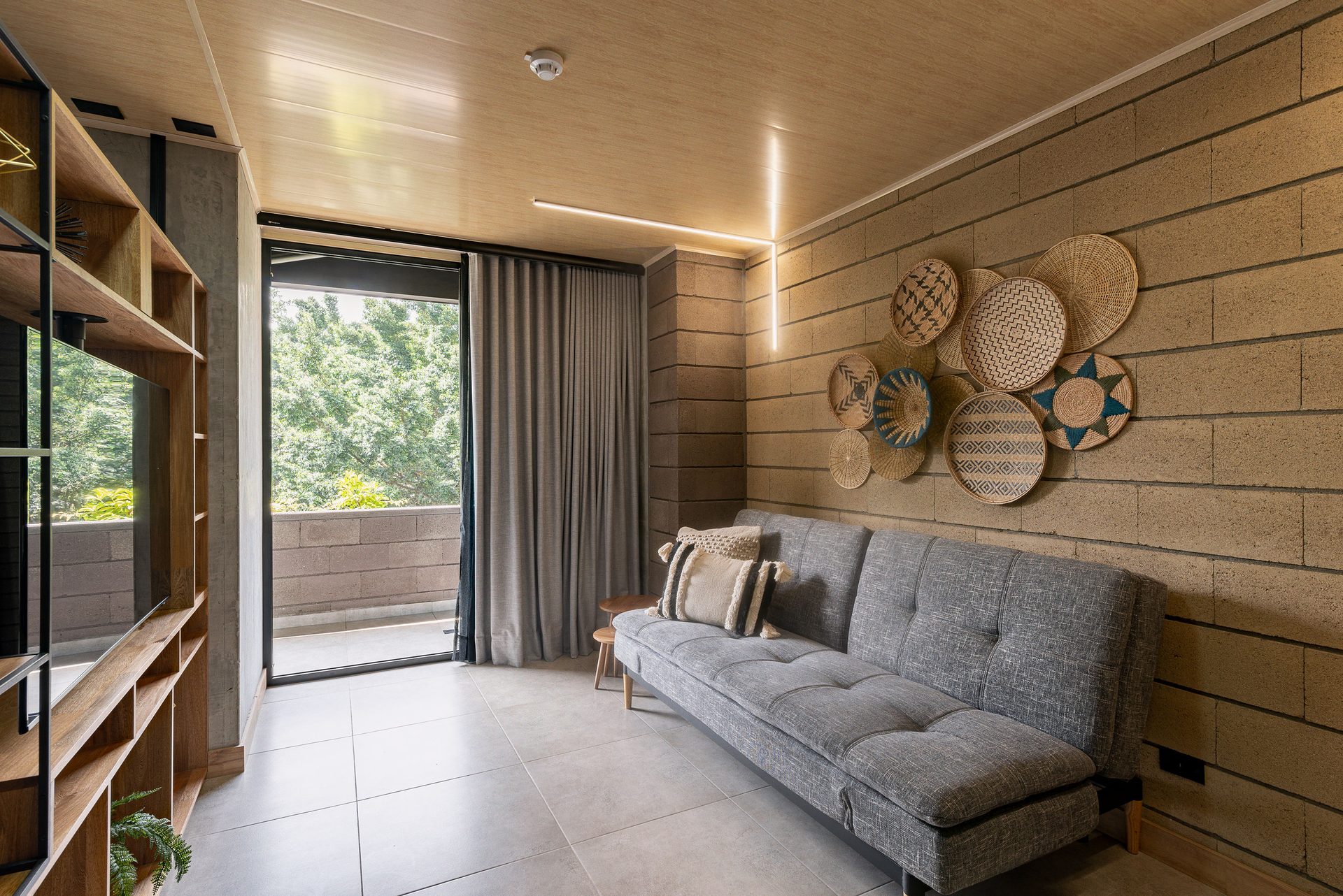 Suite sala con sofá gris y balcón