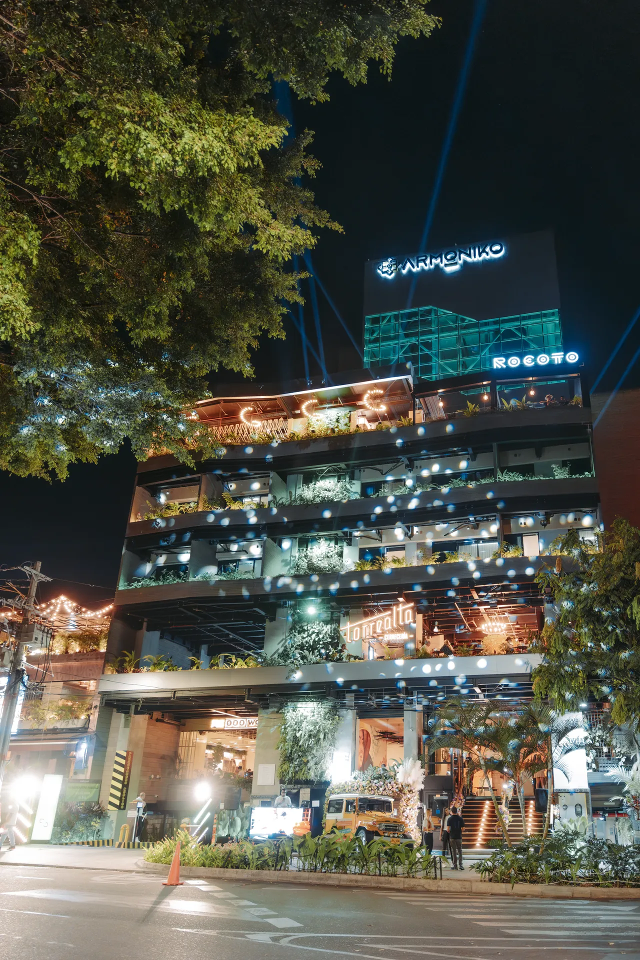 Fachada iluminada del edificio Armóniko de noche en Laureles, Medellín